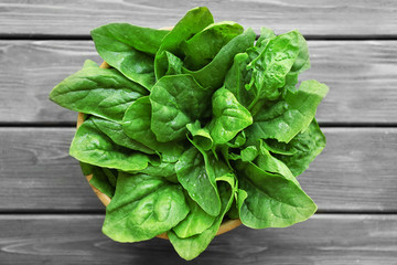 Fresh sorrel in bowl on wooden table