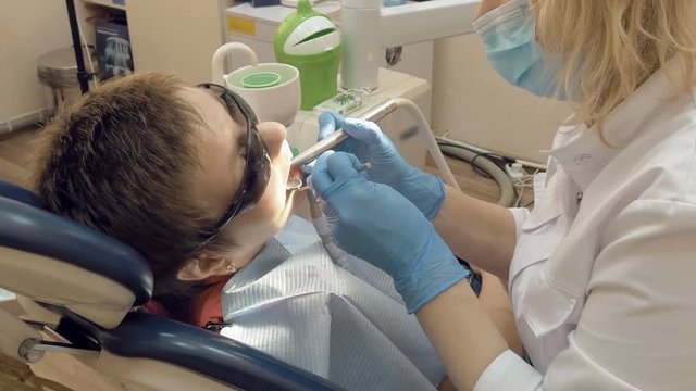 Woman at the dentist clinic office gets dental medical examination and treatment. Odontic and mouth health is important part of modern human life that dentistry help with.