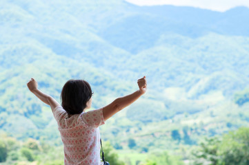 Asian woman standing at balcony and looking on the landscape.