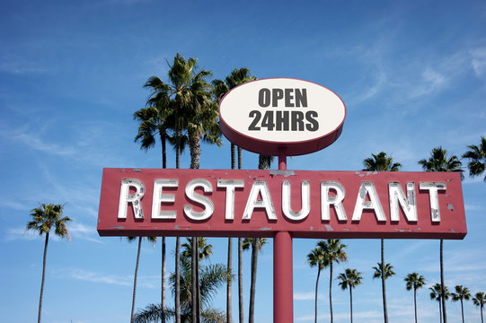 aged and worn vintage photo of old neon restaurant sign with palm trees