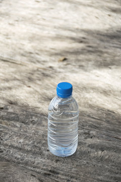 Plastic water bottle on wooden table texture. Fresh concept.