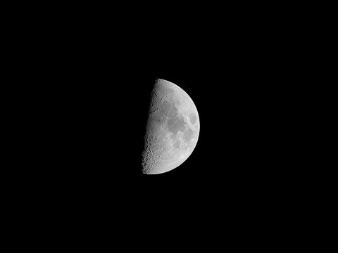 Half moon, isolated on black background for design. Black and white photo with high detailed surface (mares, craters, ridges).