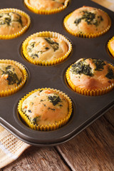 muffins with fresh spinach and feta cheese close up in baking dish. vertical
