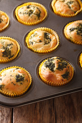 muffins with spinach and feta close up in baking dish. vertical

