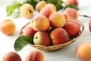 Naklejka na ściany i meble Sweet peach fruit in basket on white wooden table