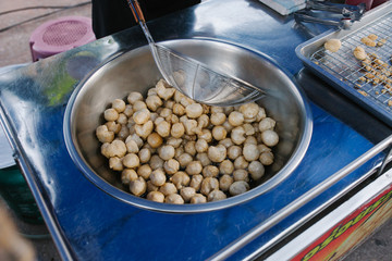 Cooking Deep frying fishball in the pan in hot oil.