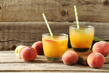 Glasses of peach juice on grey wooden table