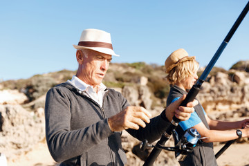 Senior man fishing with his grandson