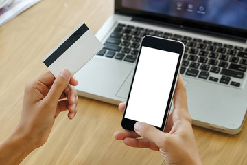 Beautiful woman hands holding a credit card and using smart phone for online shopping.