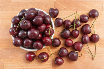 cherries in a white bowl on the wood tabel