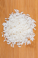 White uncooked rice isolated on wood background