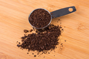 Coffee beans and grounds isolated on wood background