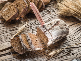 Sliced black bread on the wooden plank.