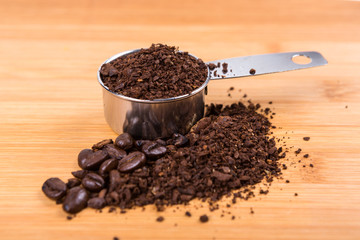 Coffee beans and grounds isolated on wood background