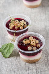 Ready berry cheesecake in a plastic jar with white currant. Dark