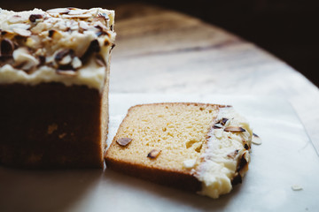 Piece of sliced almond cake on rustic wooden table