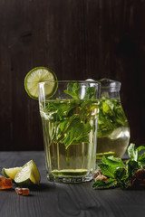 Mint iced tea with lime in the glass. Dark background.