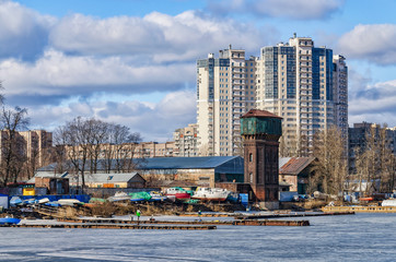 Saint Petersburg, Russia, March 21, 2015. The Galernaya Harbor at the Vasilievsky island. The old water tower is much lower than the modern buildings.