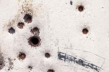 rusty and scratched metal panel background with bullet holes