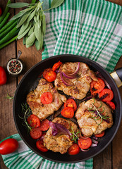 Juicy pork steak with rosemary and tomatoes on pan. Top view