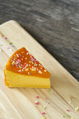 Orange cake slice on wood plate
