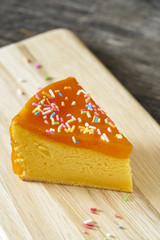 Orange cake slice on wood plate