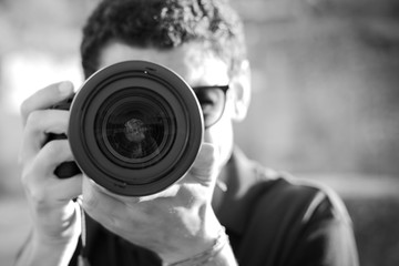 Ritratto di ragazzo che scatta fotografia con fotocamera reflex in bianco e nero