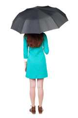 young woman under an umbrella. Rear view people collection.  backside view of person.  Isolated over white background. The girl in a blue dress with brown boots hiding under an umbrella