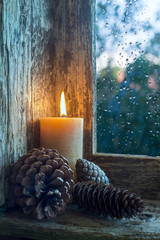 lit candle and pine cones