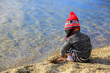 Little girl is playing by the water of Lake Wanaka, New Zealand