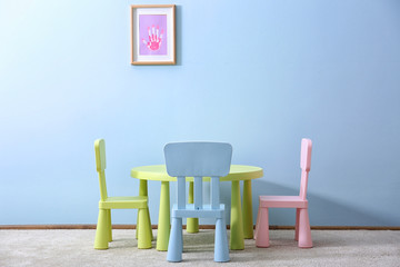 Children chairs and table on blue wall background
