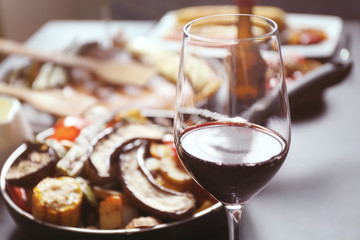 Glass of wine and grilled vegetables on served table