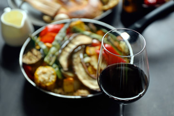 Glass of wine and grilled vegetables on served table