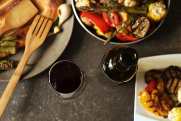 Grilled vegetables and glass of wine on served table