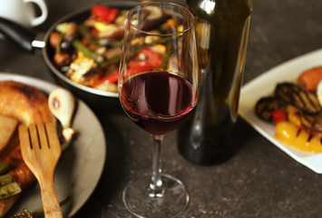 Glass of wine and grilled vegetables on served table