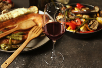 Glass of wine and grilled vegetables on served table