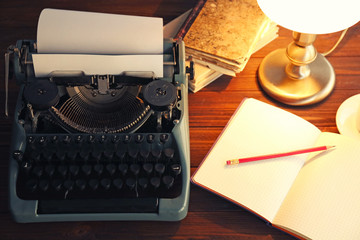 Old typewriter and notebook on the table, top view