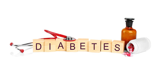 Wooden cubes with word Diabetes and stethoscope on white background