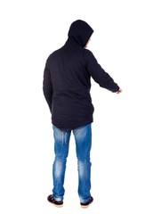 Back view of pointing young men in parka. Young guy gesture. Rear view people collection. The guy while wearing a hood on his head is pointing down.