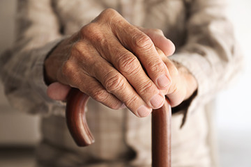 Old man hands on walking stick