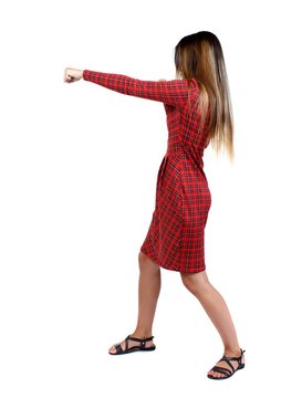 skinny woman funny fights waving his arms and legs. girl in red plaid dress stands sideways and punches.