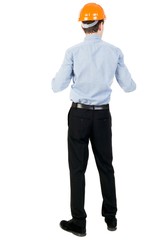 Backview of an engineer in construction helmet stands. Curly businessman in a light jacket and a helmet peering forward.