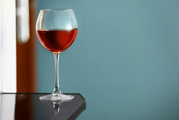 Glass with red wine on table