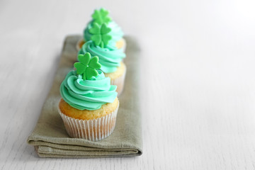 Tasty cupcakes with clover on napkin. Saint Patrics Day concept