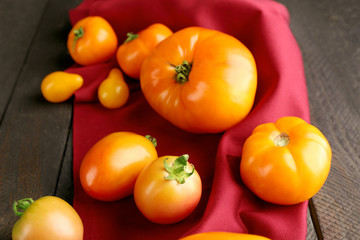 Composition of red and yellow tomatoes on dark wooden background