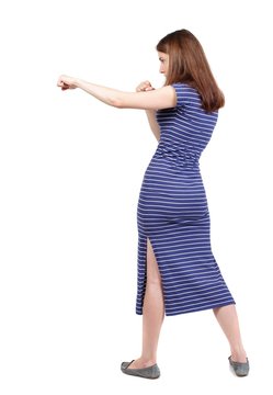 skinny woman funny fights waving his arms and legs. brunette in a blue striped dress stands sideways and hit his foot.