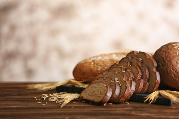 Slices of rye bread with spikes and wheat on the wooden table