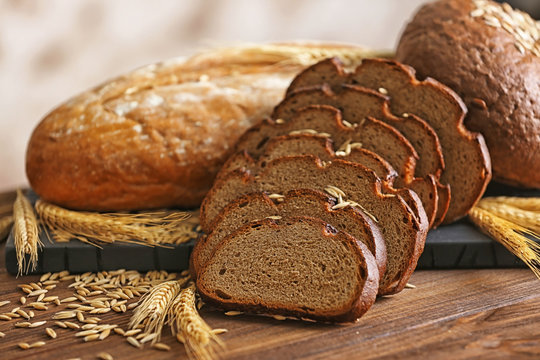 Slices of rye bread with spikes and wheat on the wooden table
