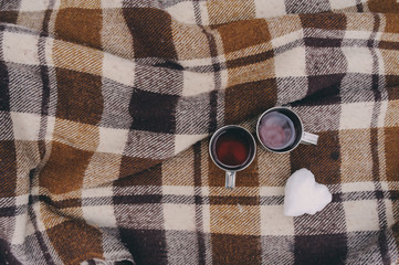 winter picnic on the snow. Hot tea, thermos and snowball heart on cozy warm blanket. Outdoor seasonal activities.