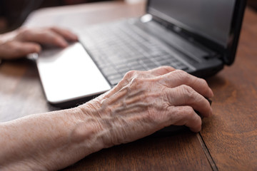 Senior hand using the mouse of a computer